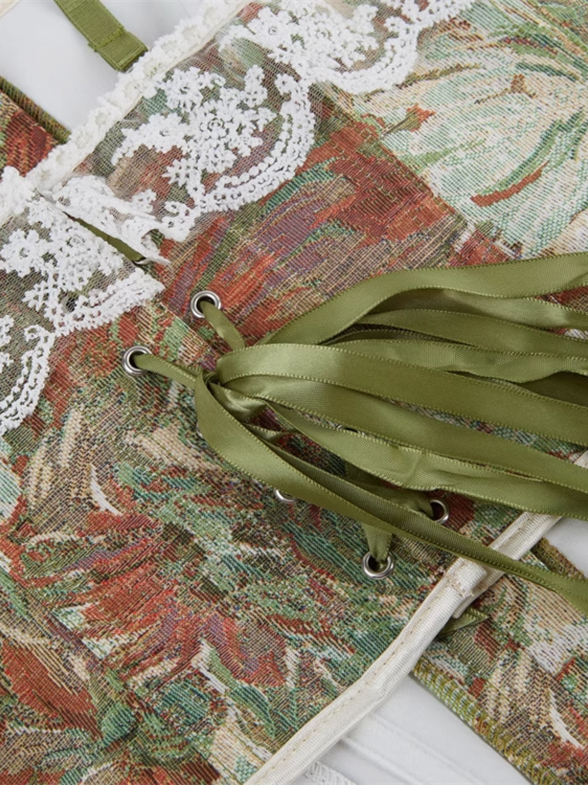 Decorative box with floral pattern and green ribbons on a white background