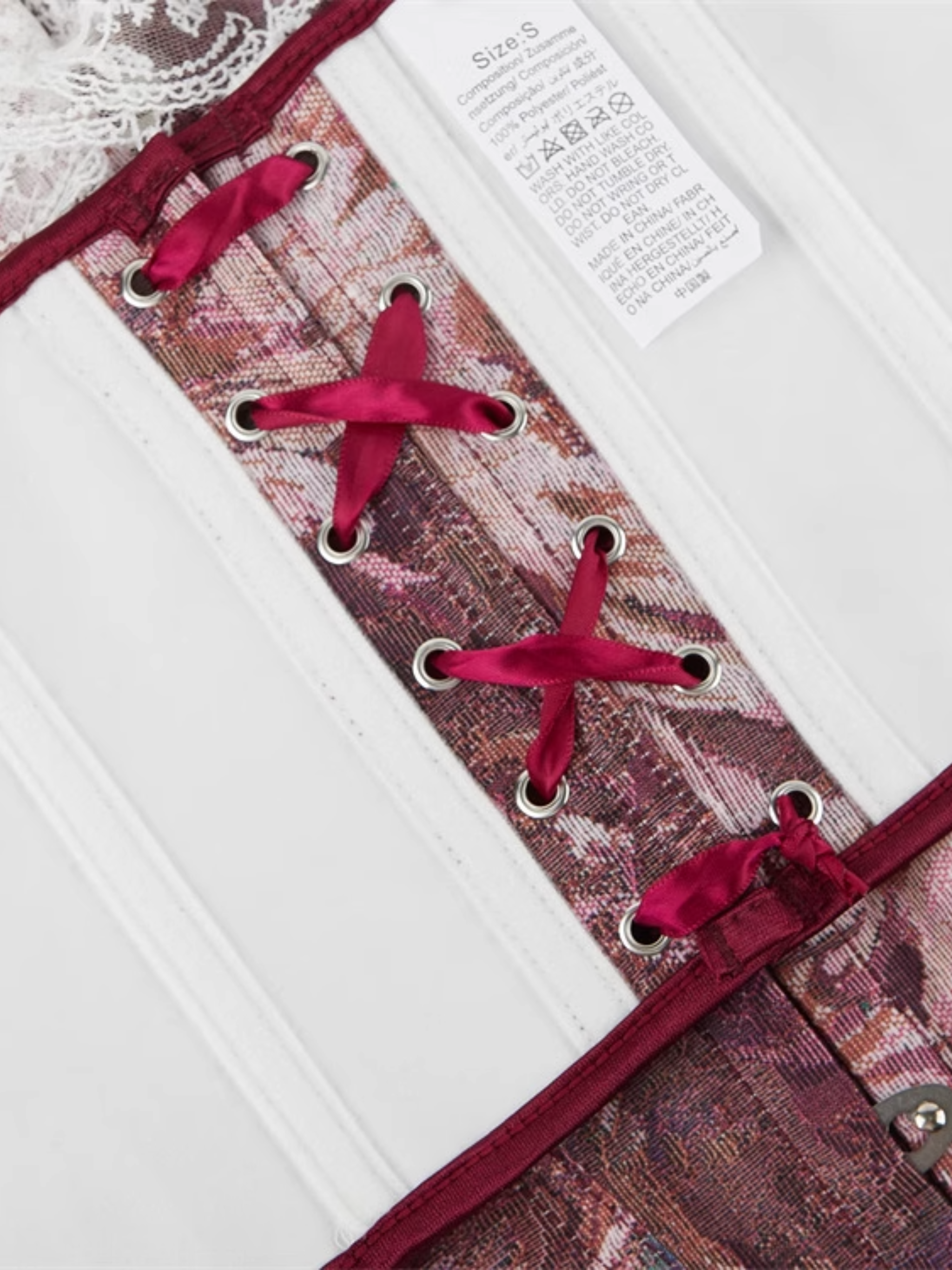 Close-up of a patterned corset with red laces on a white background