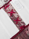 Close-up of a patterned corset with red laces on a white background